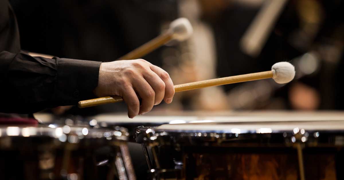 Close-up of hands playing the timpani in the orchestra 