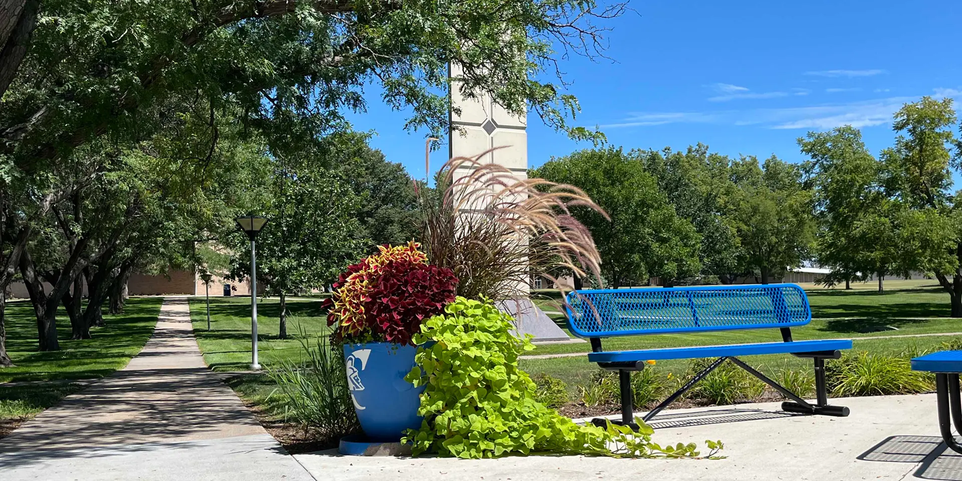 Beatrice Davis Clock Tower with a flower pot branded with the Trojan logo in the foreground